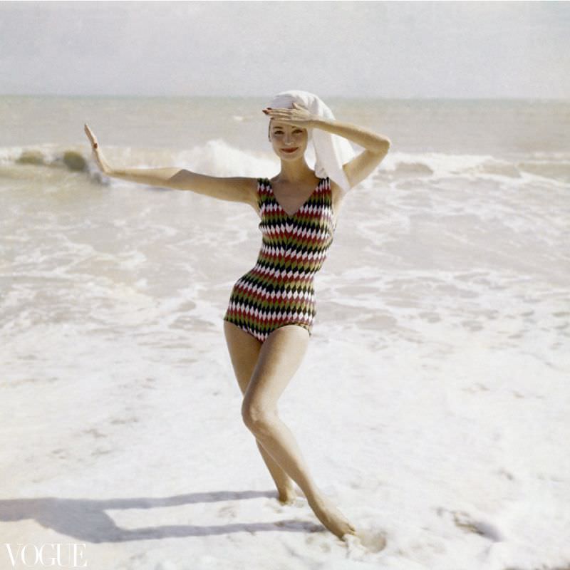 Model standing on beach wearing a bathing suit in harlequin-diamond wool, by Imports Int., 1957