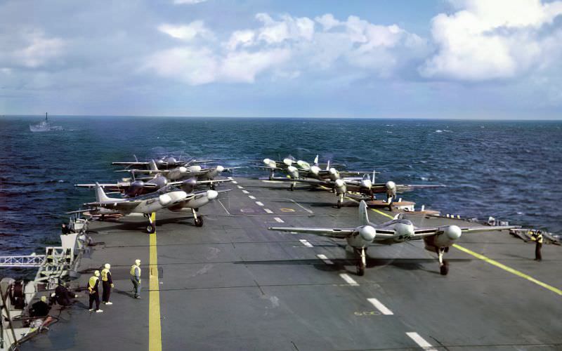 A group of eight de Havilland Sea Hornets of the Fleet Air Arm line up on the flight deck of the Royal Navy aircraft carrier HMS Implacable (R86) during a sea exercise in July 1950