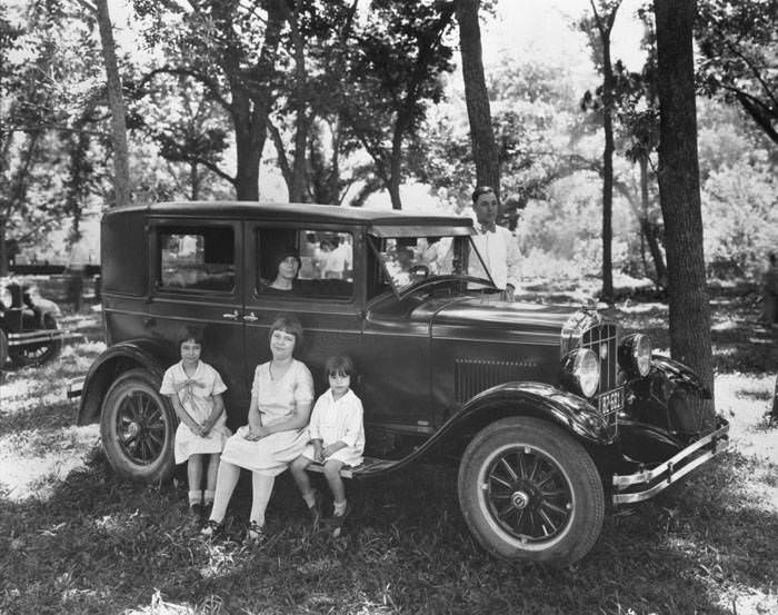 Nellie Ankenman Masterson seated in car with four of her children beside it, 1928