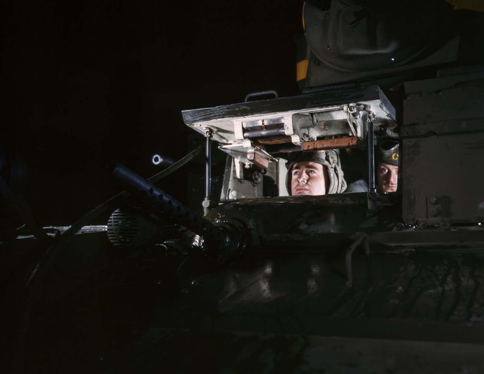 A driver peeks out from a light tank.