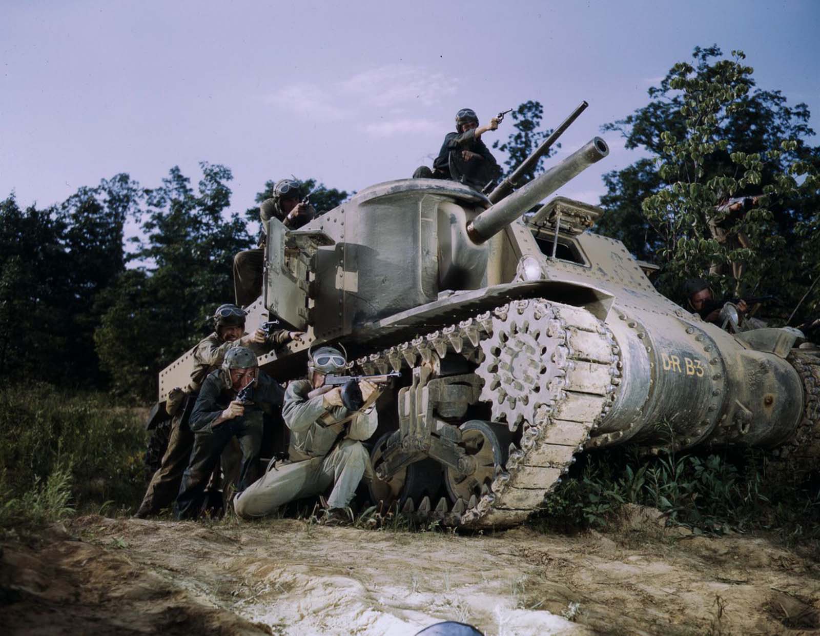 An M3 tank crew aim small arms.