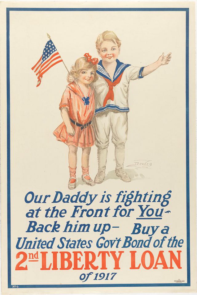 A boy waving a flag and a girl stand beside one another