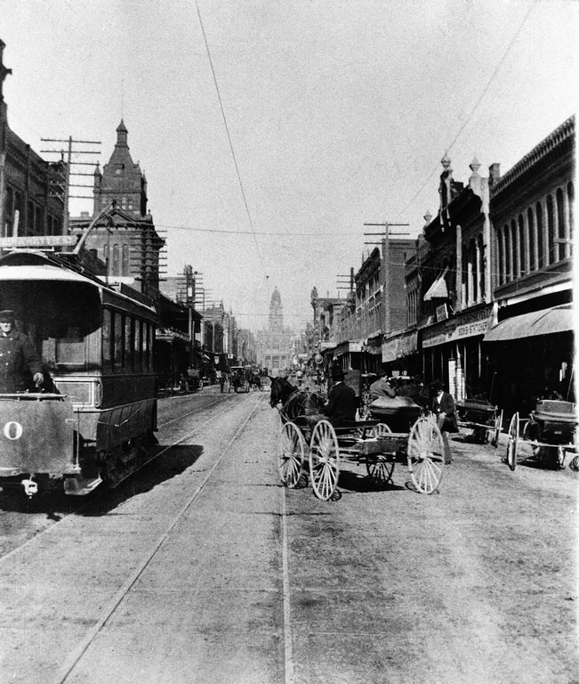 Electric street car next to horse drawn buggy in downtown Fort Worth, Texas, 1896