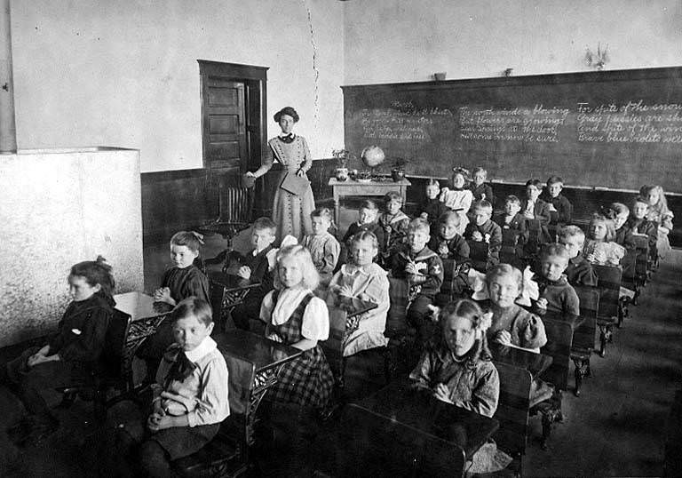 Interior of classroom showing school children seated at desks, 1890