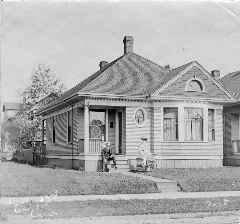 Man and woman with baby carriage near front porch of residence at 1428 23rd Ave Seattle, 1890