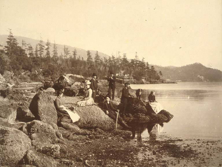 Men and women on an outing on the beach, possibly south of Alki Point, Seattle, 1889.