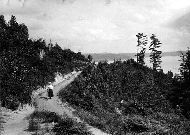 Woman with bicycle on the Lake Washington bicycle path, 1899