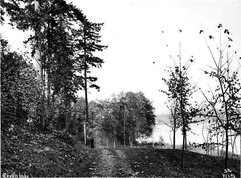 Two women walking in Woodland Park near Green Lake, 1897