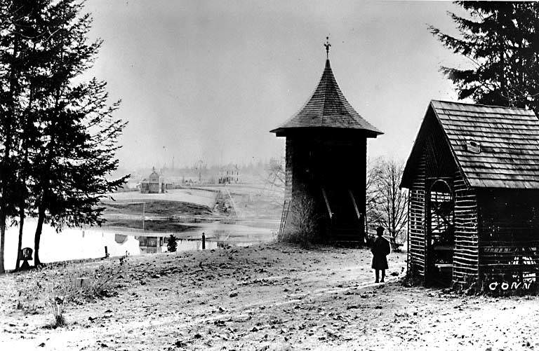 Child standing near Hunters Pride shelter looking across Green Lake from the southeast end, 1896