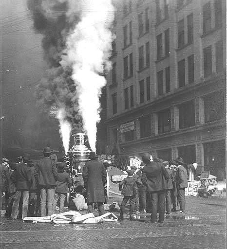 Crowd with hose cart at scene of fire, 1895