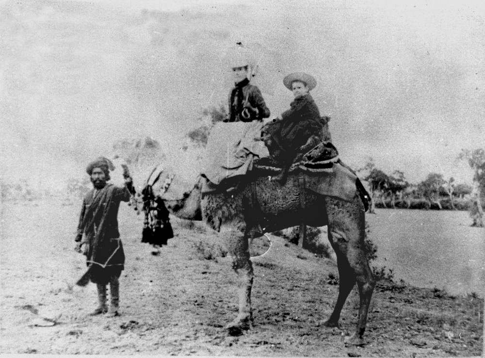 Woman and child on a camel in the Hughenden district