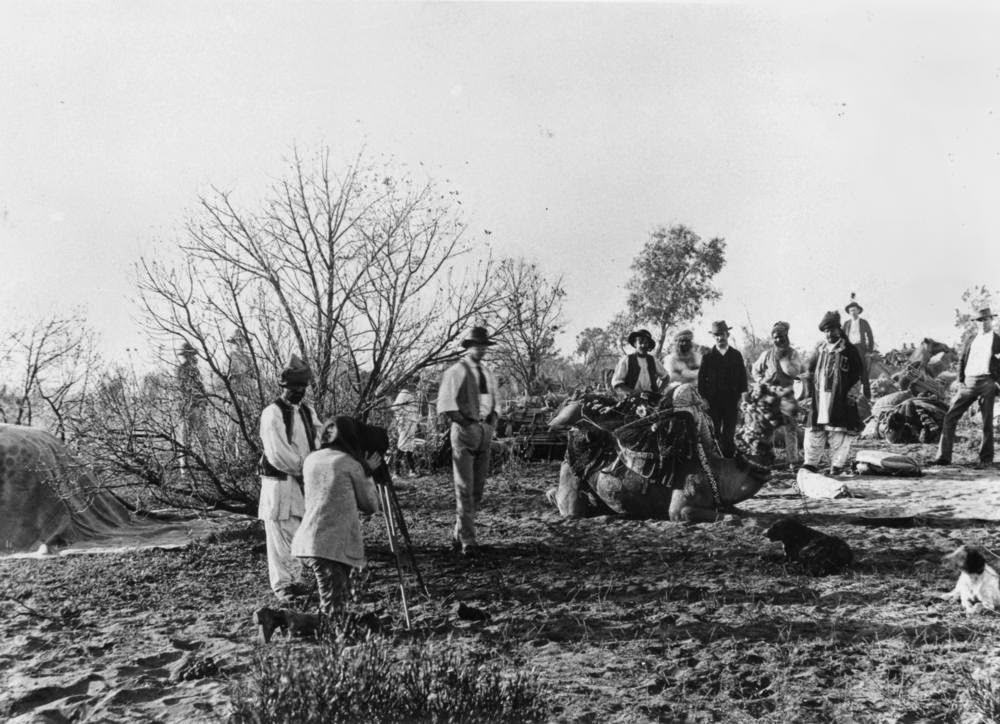 Camels and their Afghan drivers loaded with goods for the treck between Bourke and Cunnamulla, 1895