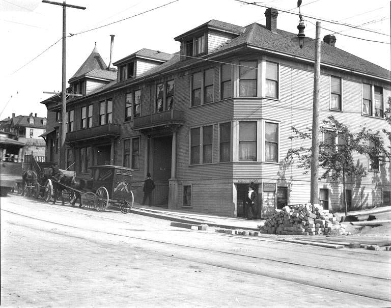 Businesses and apartments at E. Pike St. southeast corner of Bellevue Ave. E., Seattle, Washington, May 15, 1909.
