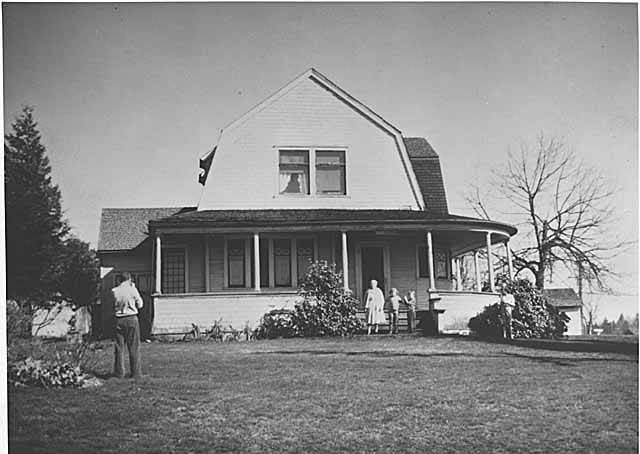 Delbert Hutchison taking picture of family in front of Hutchison residence, Bellevue, 1963