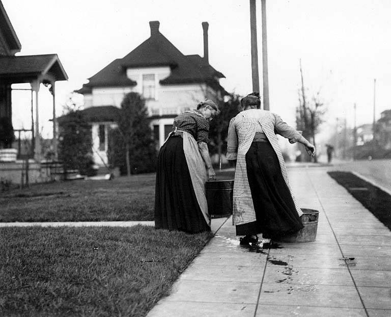 Two women carrying buckets of water from the relief wagon, Bellevue Ave., during the water shortage of November 21, 1911.