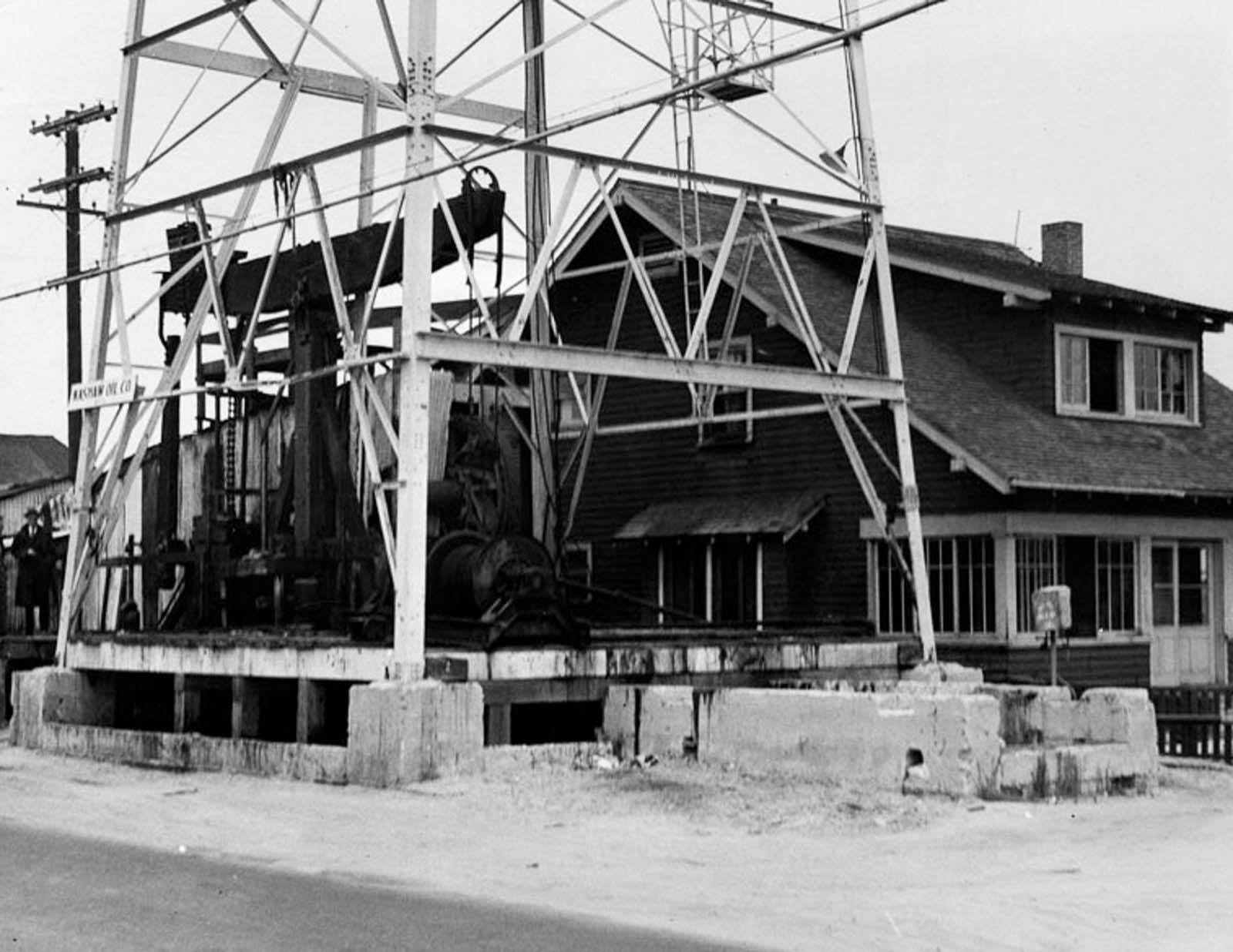 An oil derrick abuts a beach house in Venice, 1937