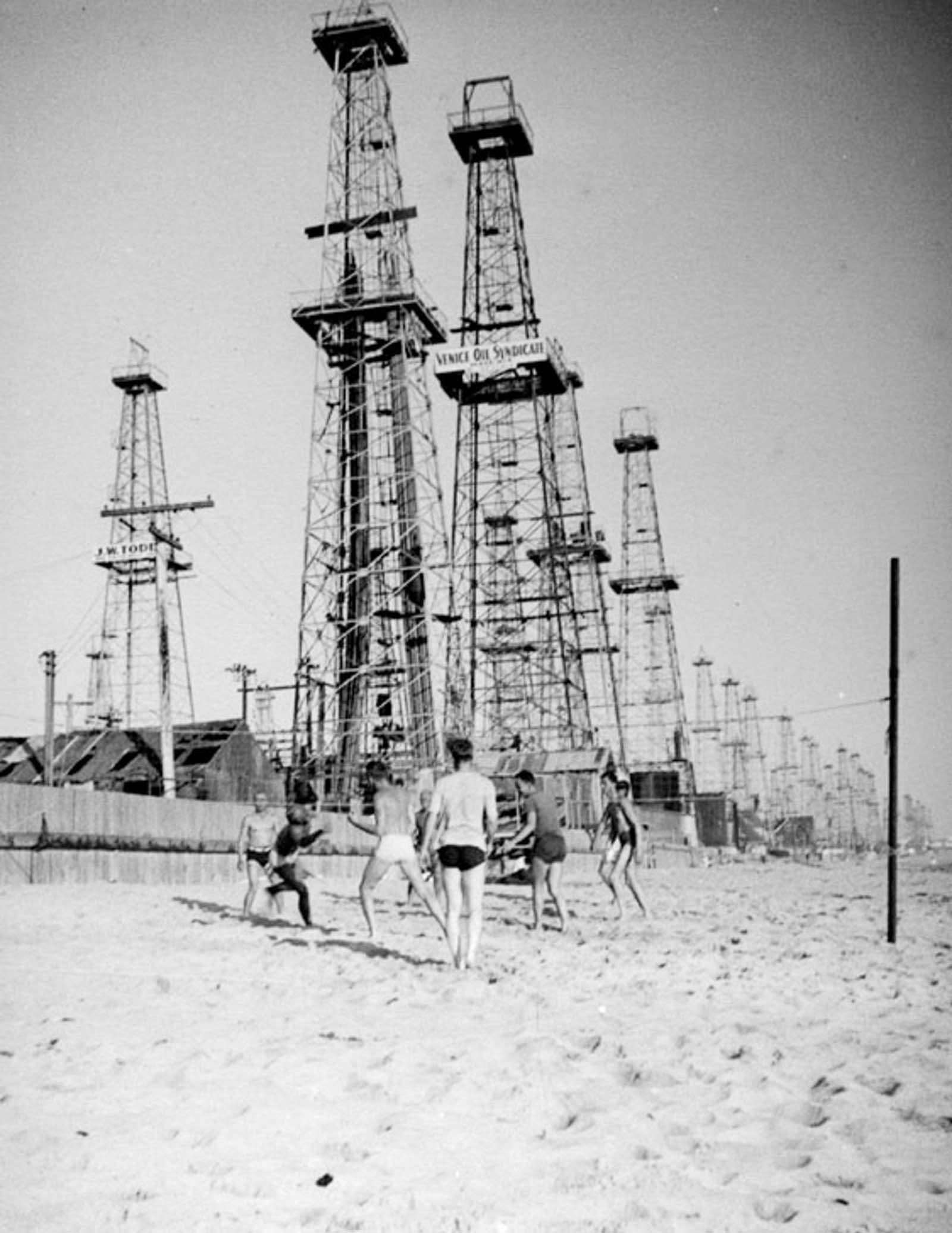 Men play volleyball on the beach next to the Venice oilfield, 1937.
