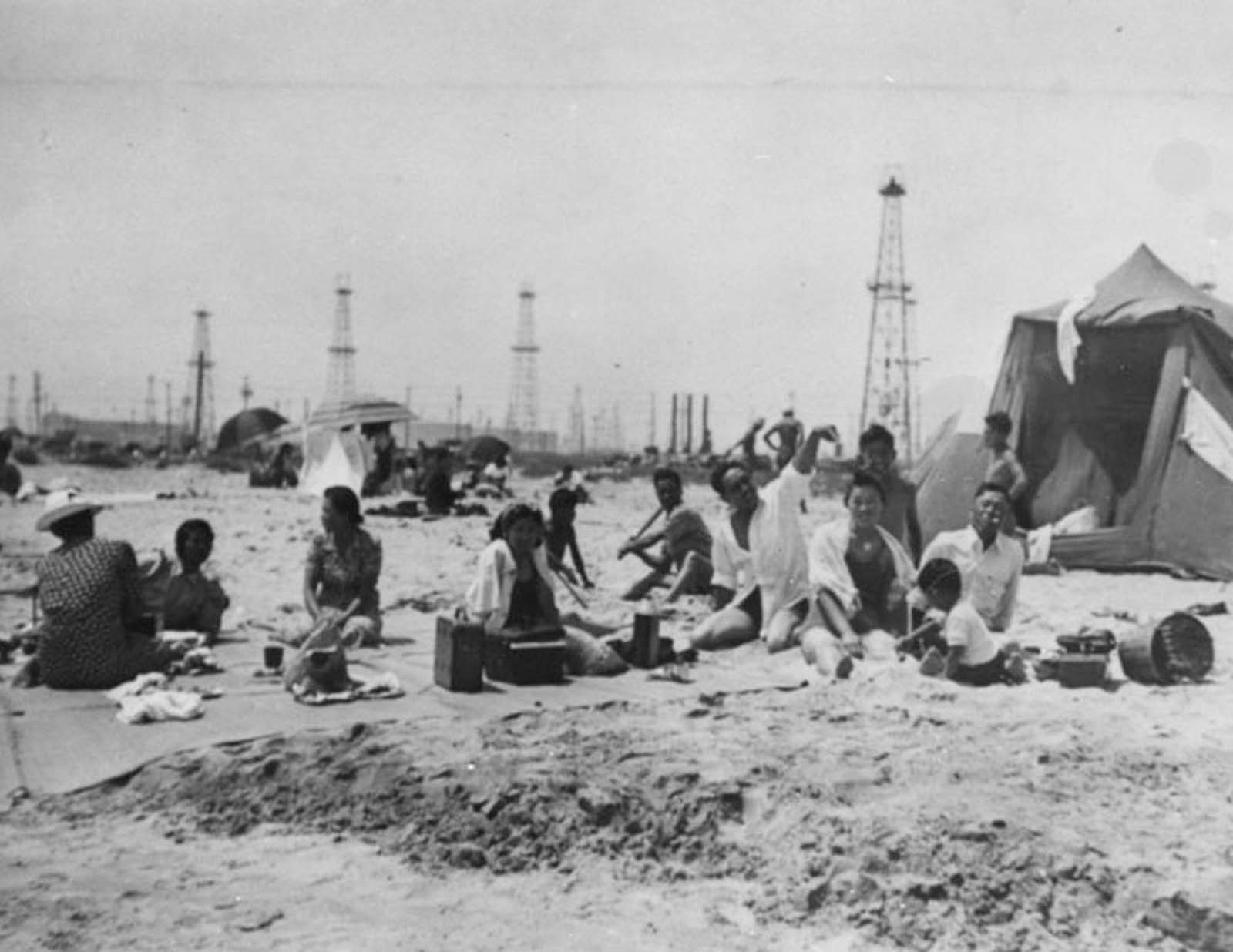 A family beach picnic with Signal Hill oil derricks in the background, 1920