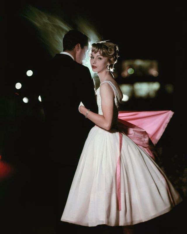 Model is wearing a skirt of white chiffon with bodice of white cotton lace, October 1957