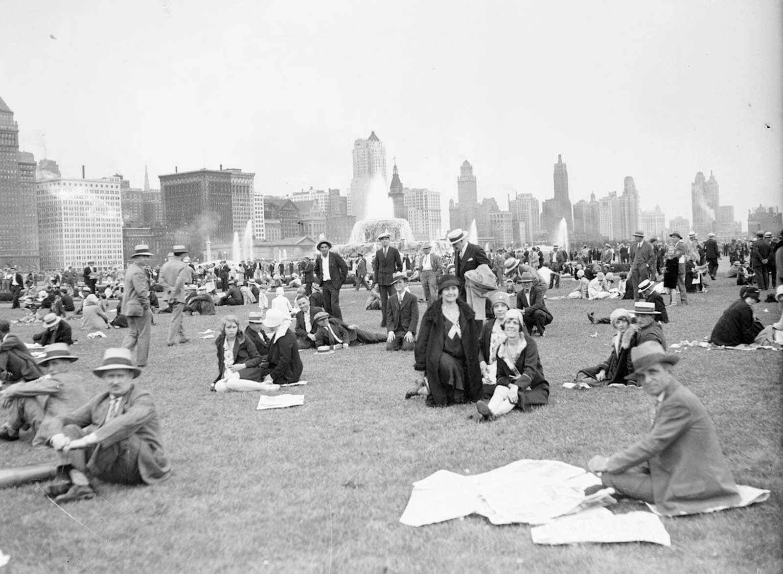 Crowds sitting and standing on a lawn in Chicago’s Grant Park.