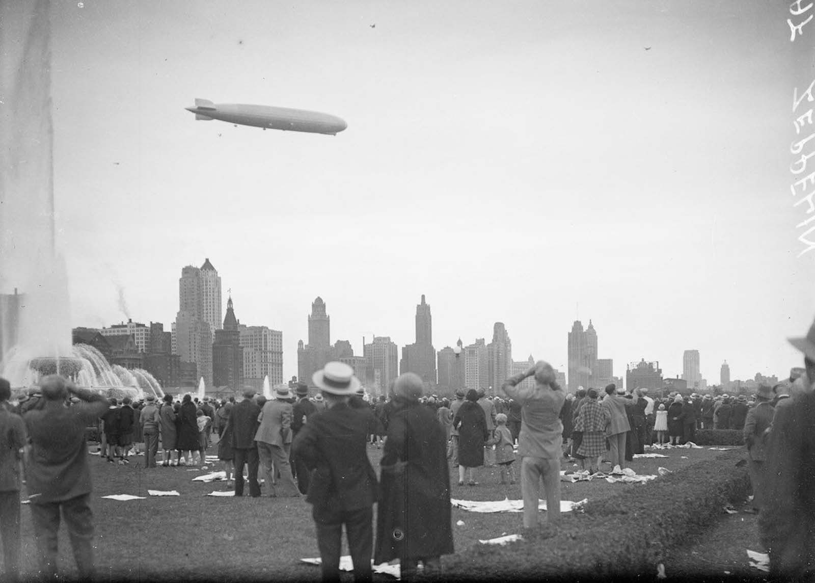 The Graf Zeppelin viewed in profile flying at a downward angle over Buckingham Fountain in Grant Park.