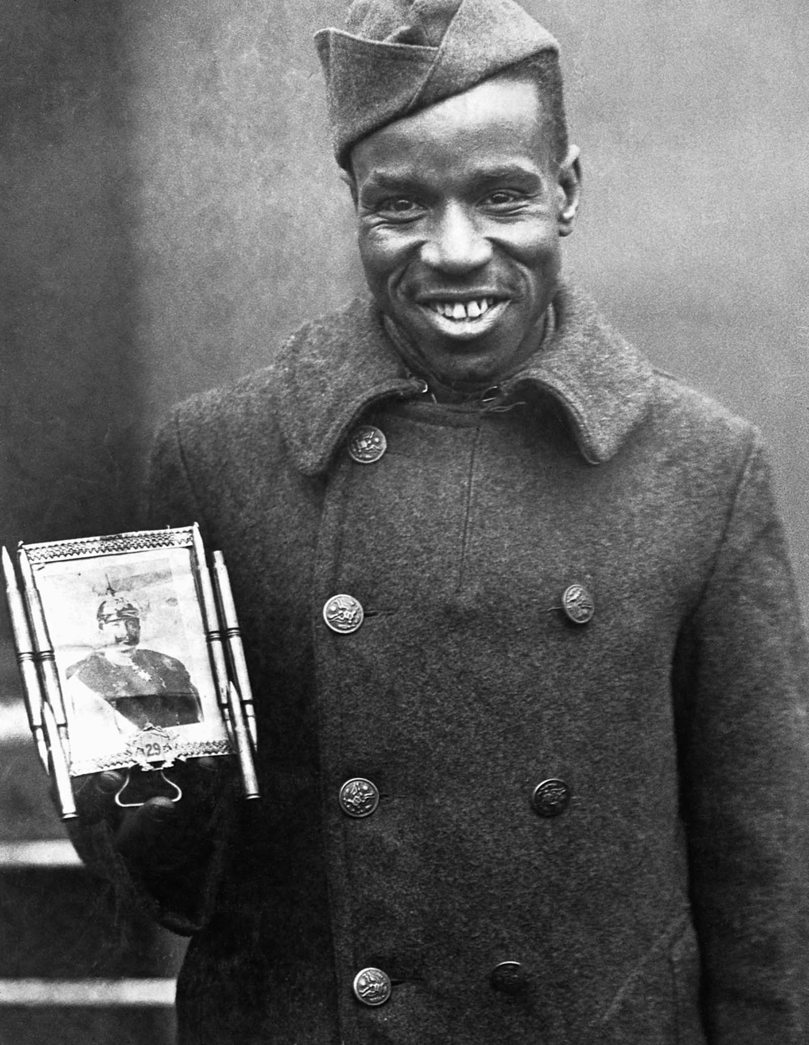 Cpl. Fred McIntyre of the 369th poses with a bullet-framed photo of Kaiser Wilhelm which he carries for good luck.