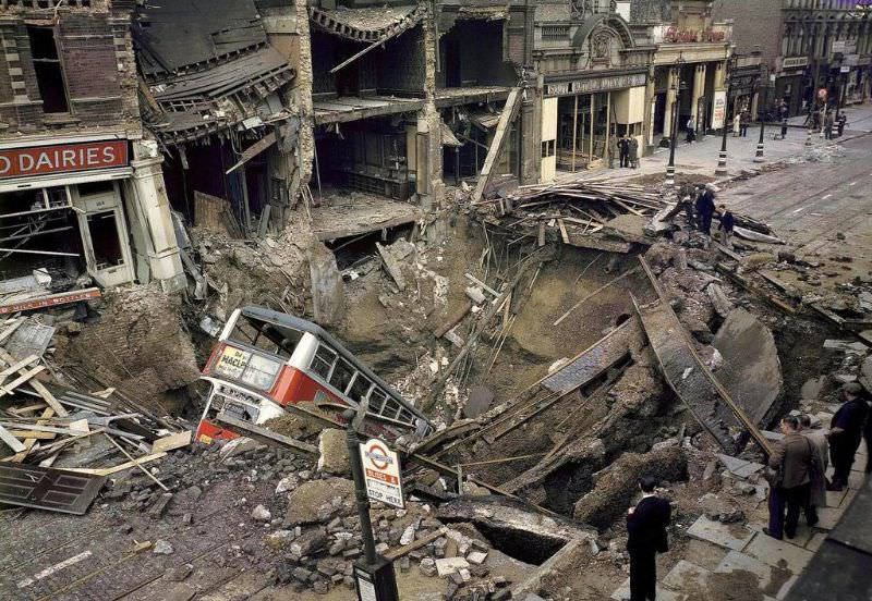 A bus is laying inside a huge bomb crater in a London street after heavy German air raid bombing attacks during the Battle of Britain, October 15, 1940