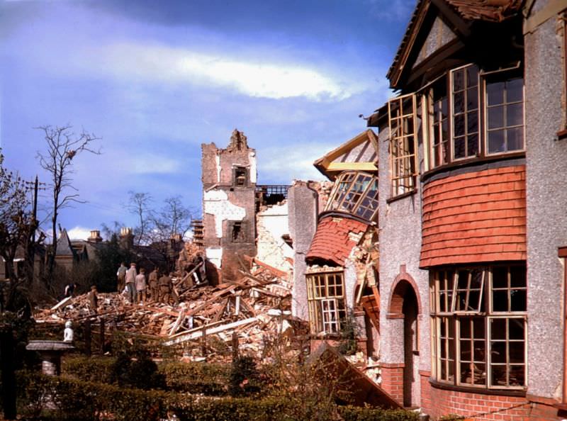 Workers clear debris from the lot where a home once stood, London, 1940