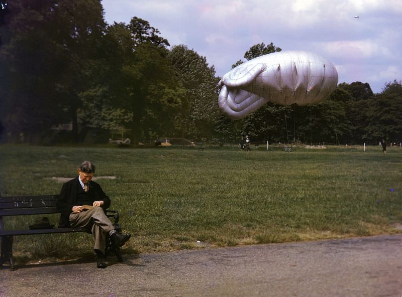 A man sits on a park bench in London, 1940