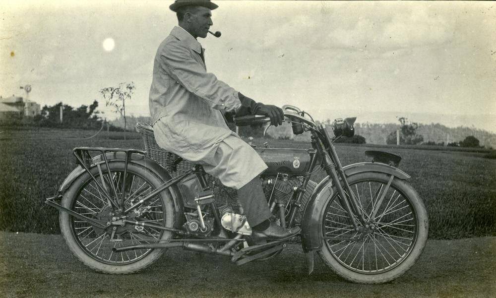 Solicitor from the Toowoomba district, wearing driving gloves and a dust jacket, on a Harley Davidson motorbike, 1930.