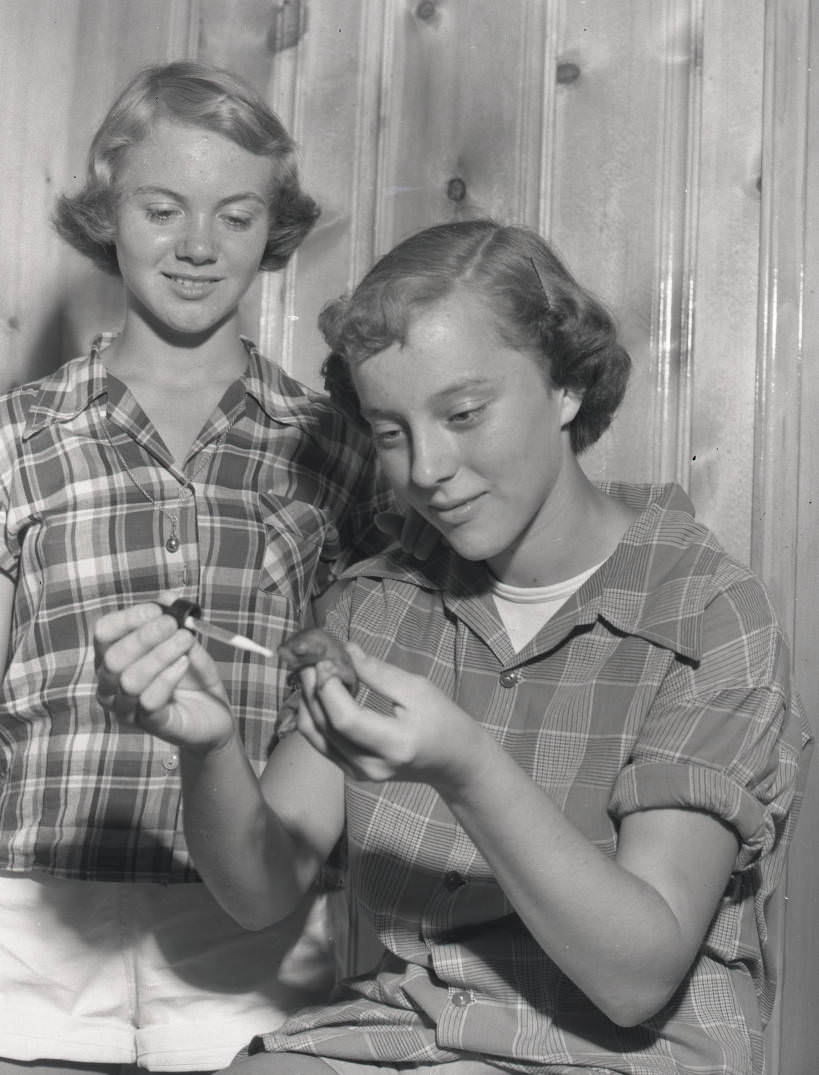 Two young women feeding a baby animal, 1950