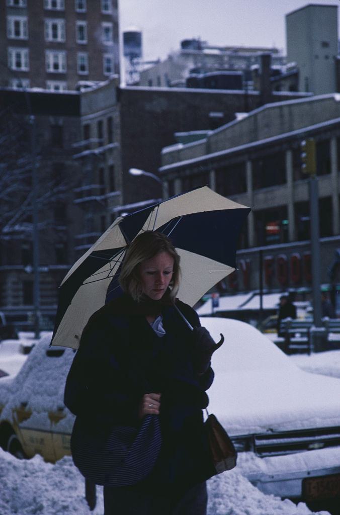 A woman walking down a street in New York City, during the blizzard of January 1996.