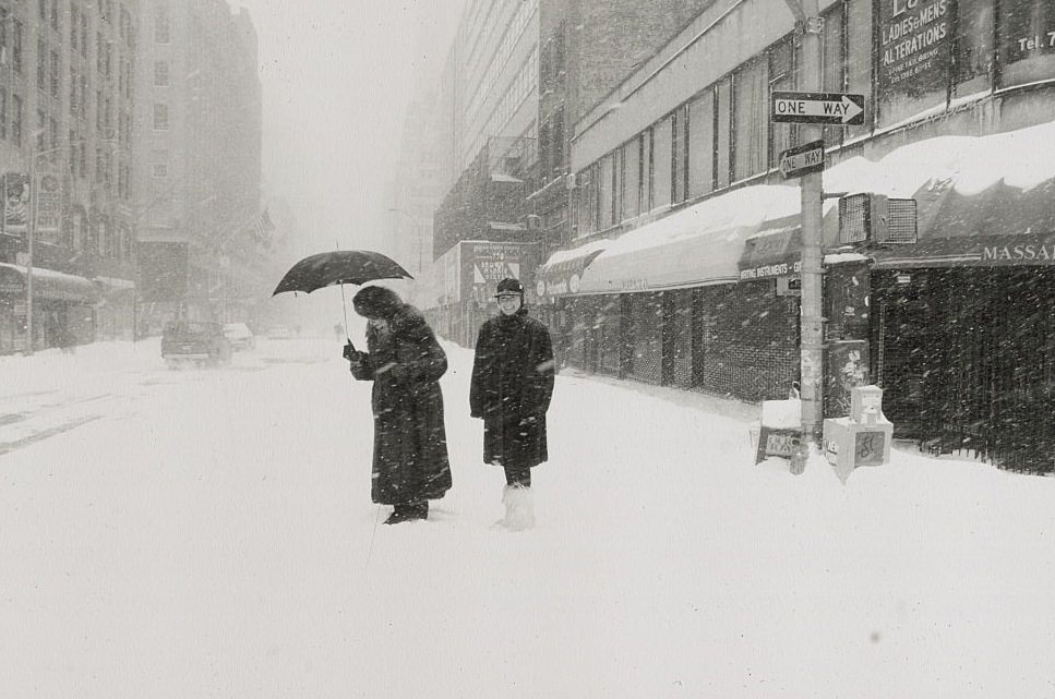 Old Woman with Umbrella and Friend Standing in Snowstorm, New York City, 1996