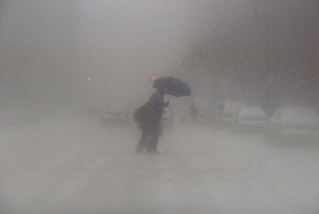 Pedestrian slowly makes his way across Pike St. during a blizzard, New York City, 1996