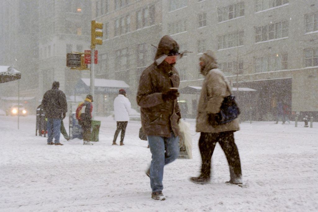 Pedestrians make their way along Sixth Ave. during a blizzard