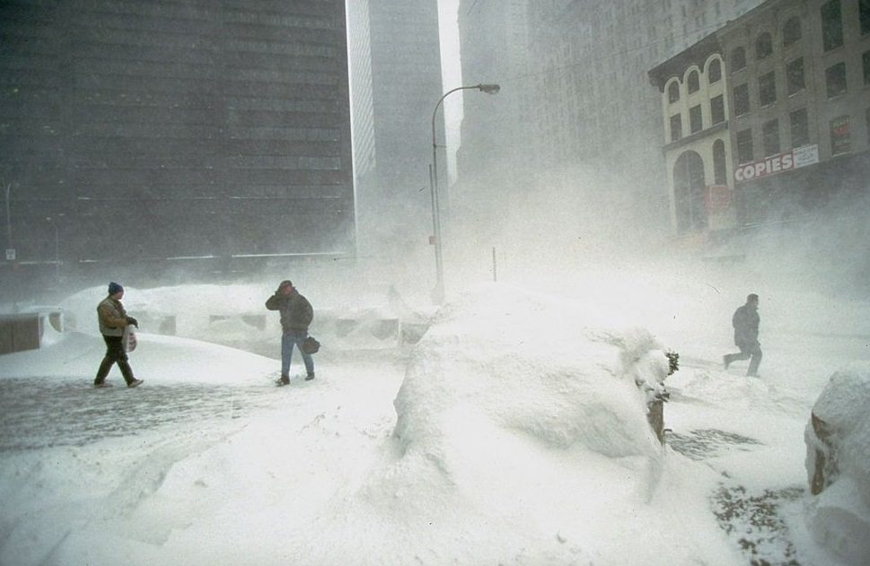 Several hardy souls crossing windy, snowswept plaza during Blizzard of 1996, in financial district.