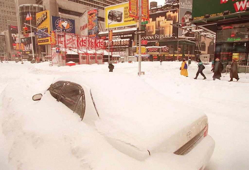 Pedestrians make their way past a buried car in New York's Times Square 08