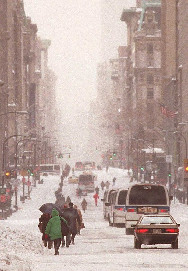 A line of pedestrians and vehicles wind their way down New York's Fifth Avenue