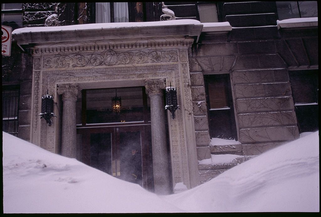 The entrance to a building is blocked by snow drifts.