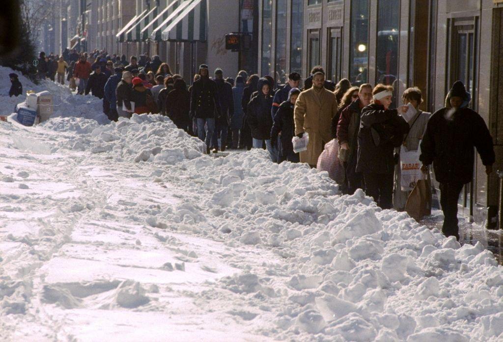 Sidewalk space is scarce as snow covers most of the road on Fifth Ave. after a blizzard.