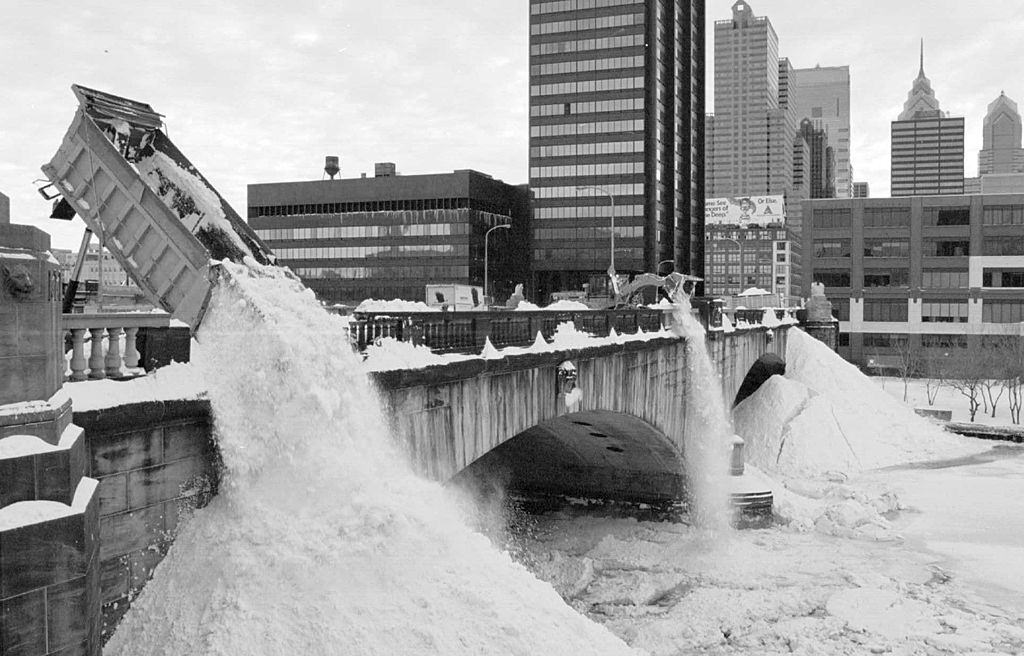 Trucks and a payloader dump snow into the frozen Schuylkill River, as Philadelphia tries to dig out from a blizzard.