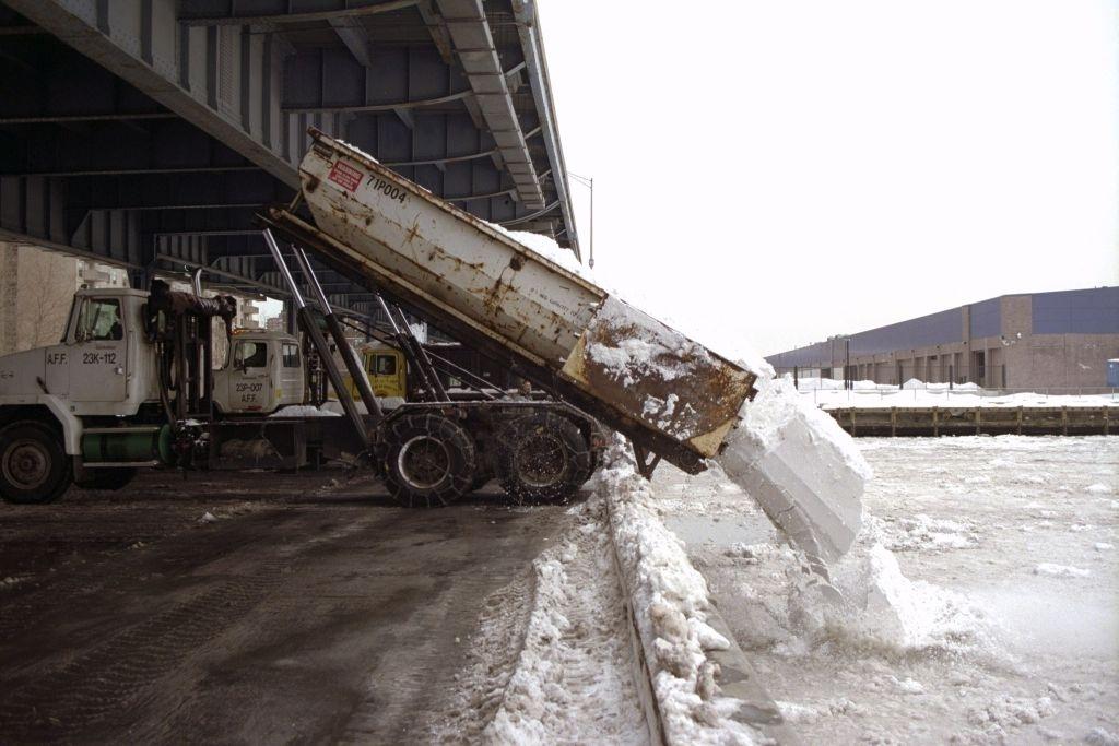 Trucks dump the snow from city streets into the East River at Dike and South Streets after a blizzard.