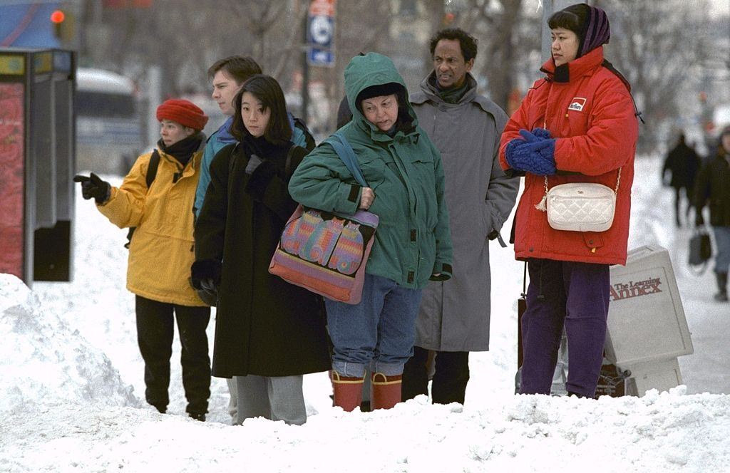 Pedestrians look at snow filled intersections on Ninth Ave. as they try to map out a way to get across the street after a blizzard.