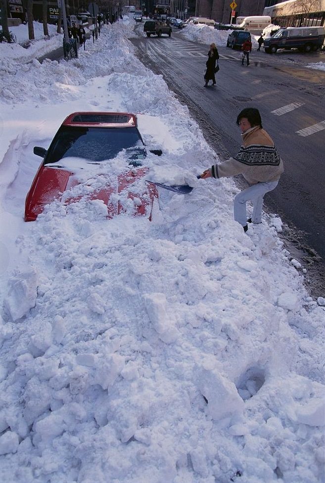 Woman Shoveling Snow off of Car