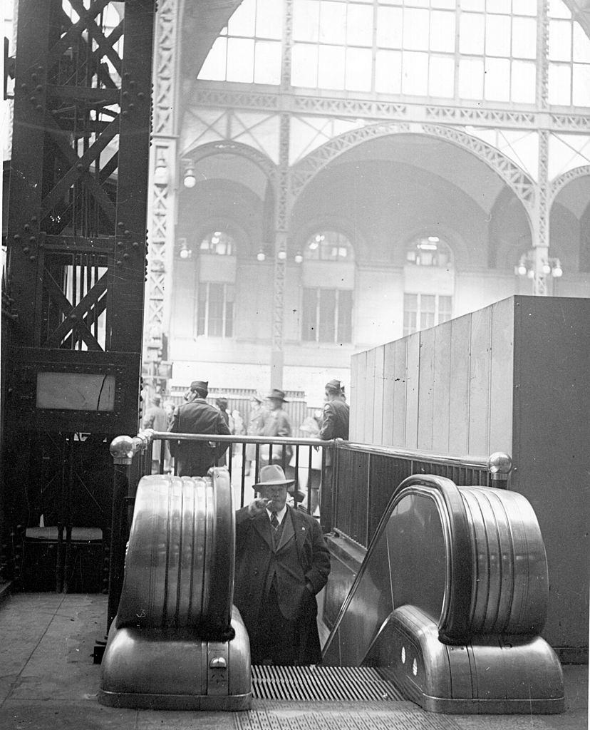 A man approaches the top of an escalator at Pennsylvania Railroad Station, New York, 1940