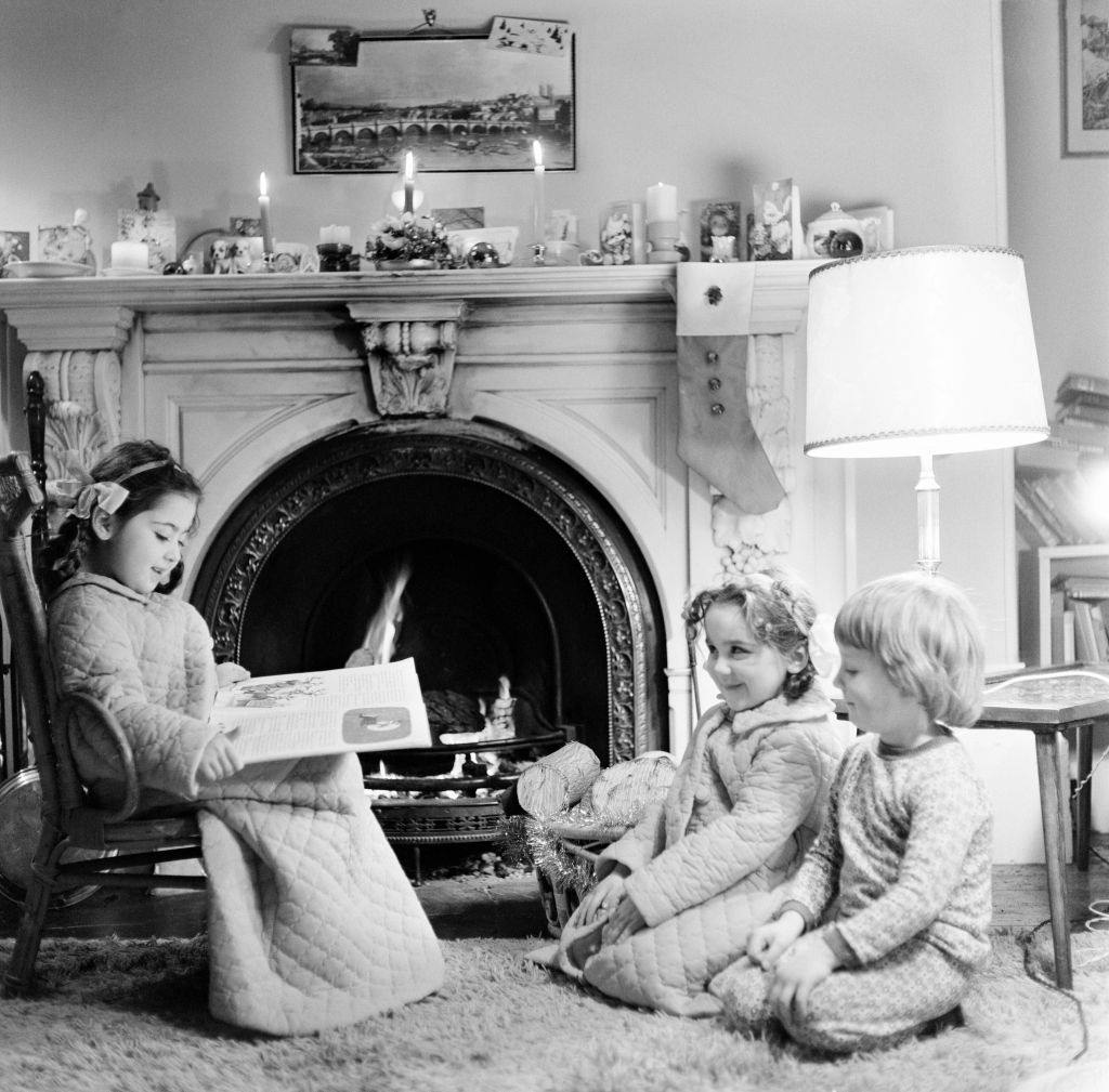 Christmas Eve, Children reading bedtime stories as they wait for Santa, Newcastle, Tyne and Wear. Posed picture taken 18th December 1974.