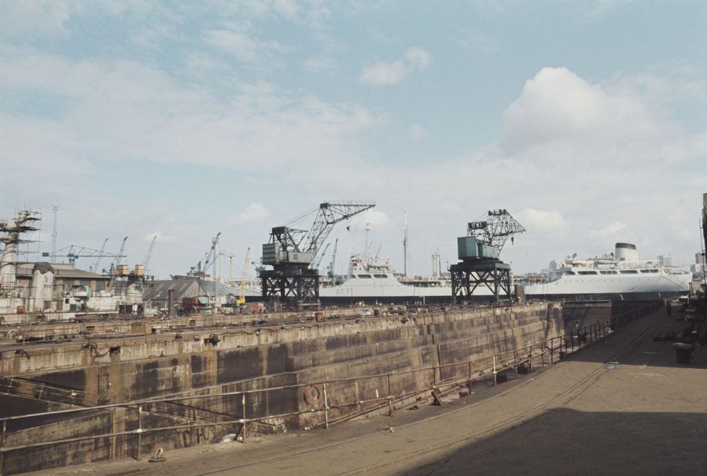 Cranes standing idle next to an empty dry dock at the Swan Hunter shipbuilding complex located on the River Tyne at Wallsend near Newcastle upon Tyne, 1972.