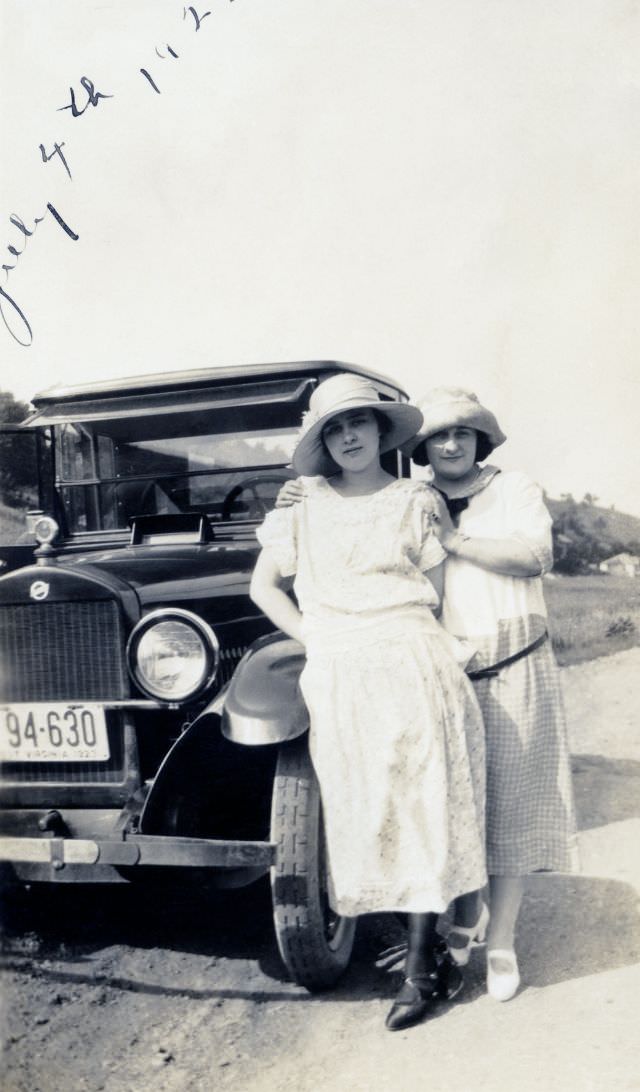 Two fashionable ladies posing with a 1923 Studebaker Light Six on a gravel road in the countryside.