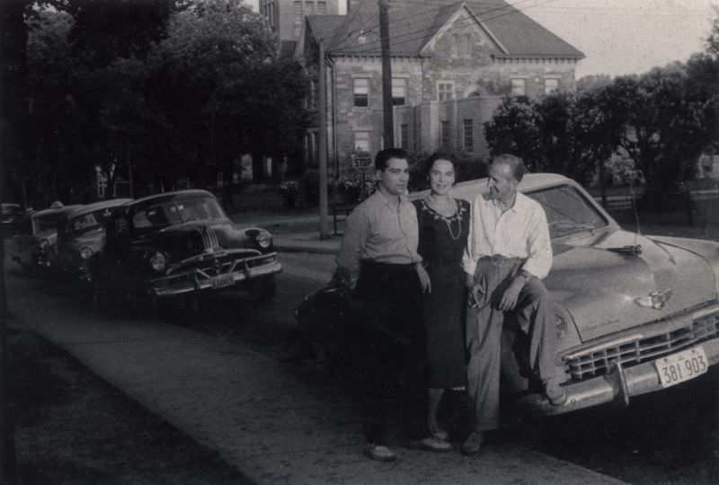 A lady and two fellows posing with a 1949 Studebaker Champion Starlight Coupe in summertime.