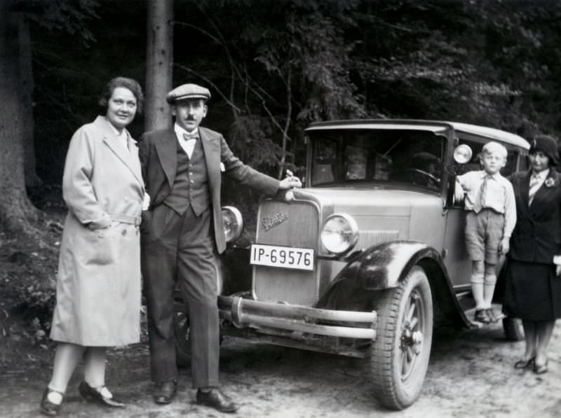Four members of a German middle-class family posing with a 1928 Studebaker Erskine Six in the countryside. T